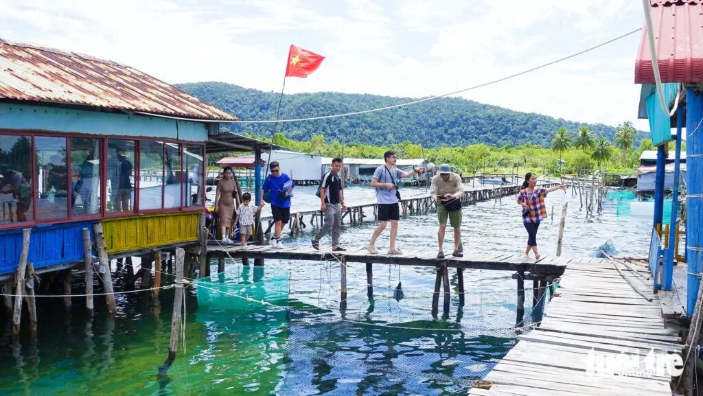 A group of people walking on a bridge in the water