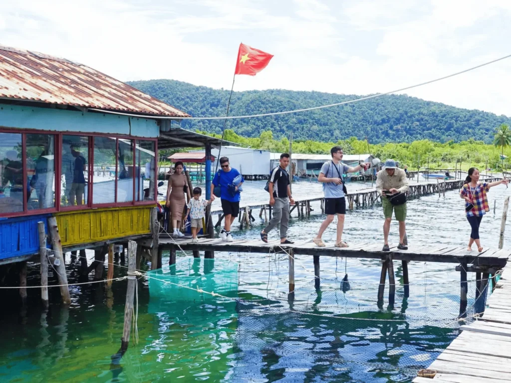 People walking on a bridge in a floating house, rach vem, phu quoc