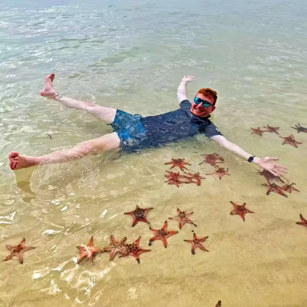 man laying among red starfish, starfish beach, phu quoc